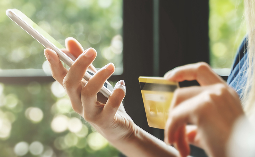 woman's hands with credit card and smartphone, Insurance Software & BPS | DXC Technology