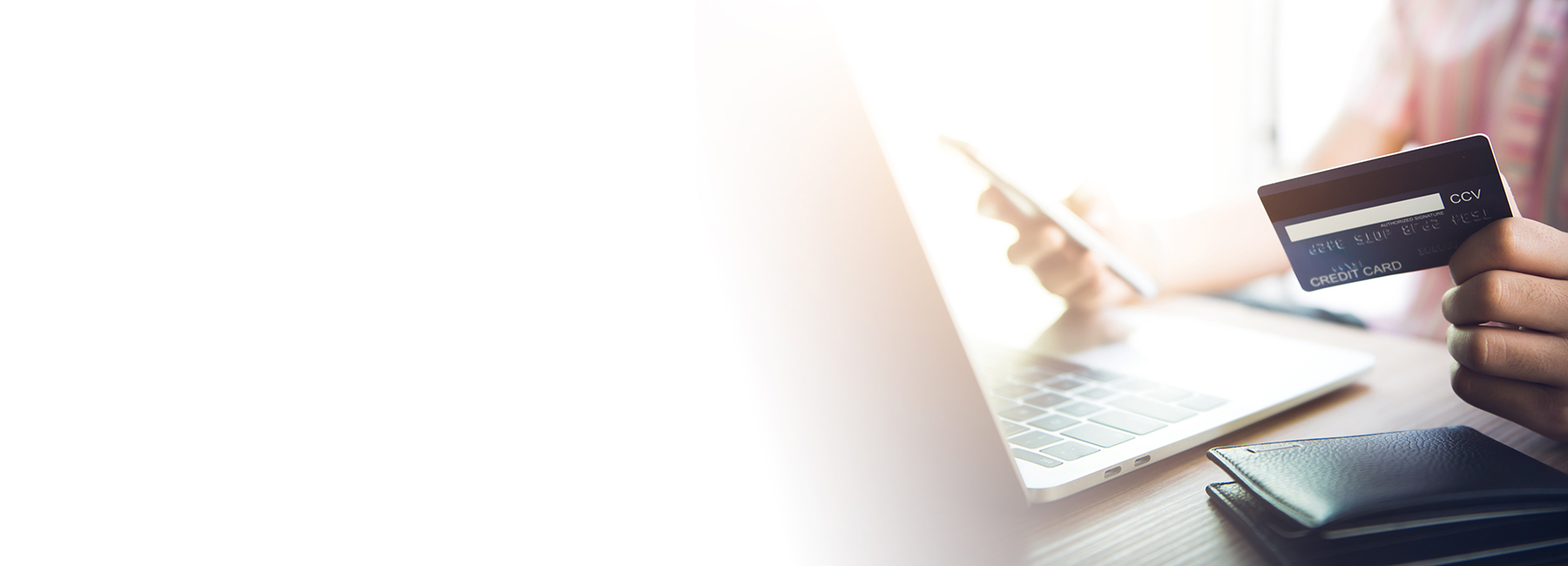 hand holding credit card at laptop, Card issuing | DXC Technology