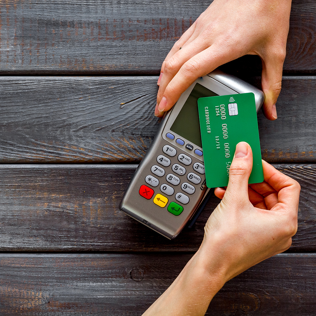 hands with credit card machine, Merchant acquiring, Banking BPS | DXC Technology
