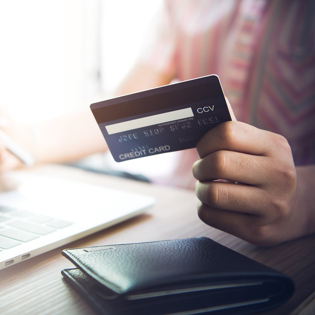 hand holding credit card at laptop, Card issuing, Banking BPS | DXC Technology