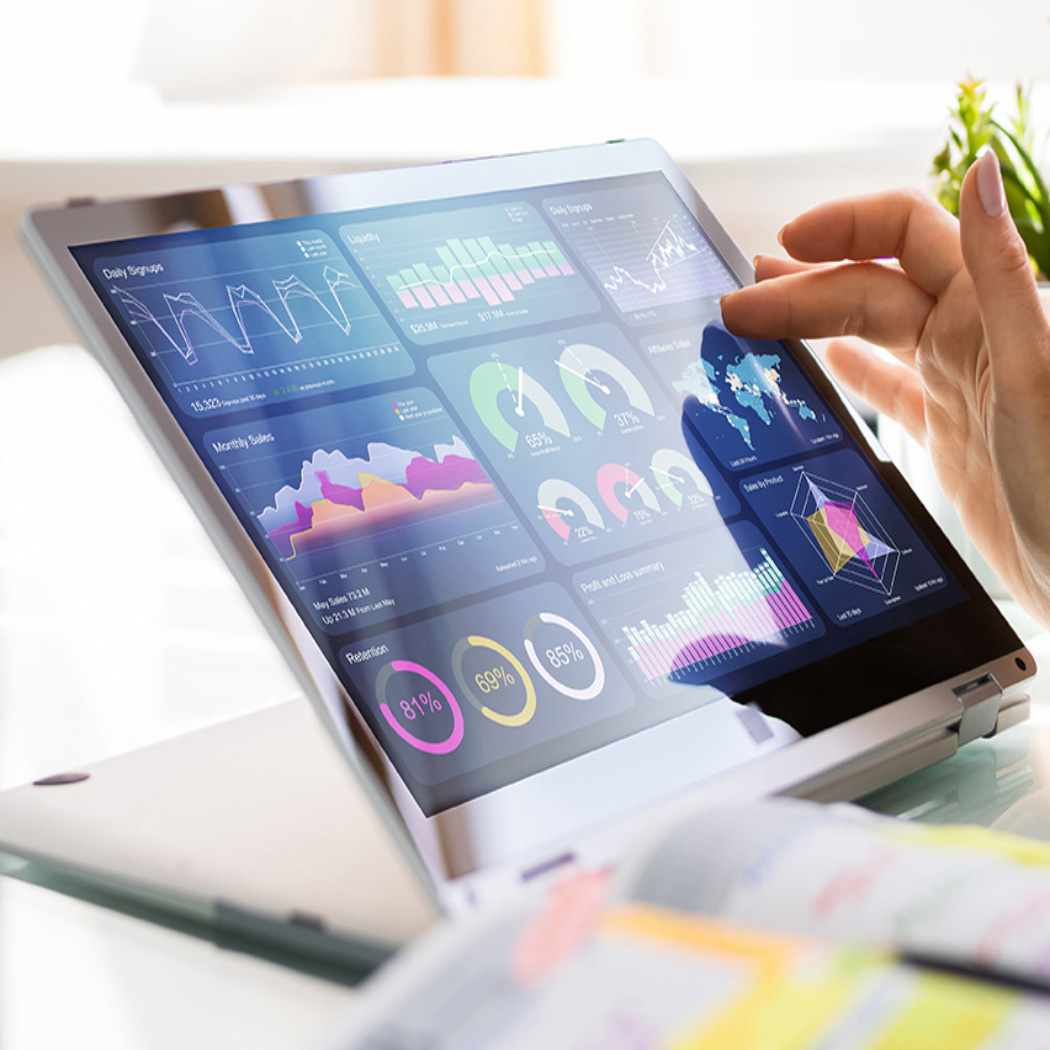 Woman's hand on touchscreen tablet showing colorful data, charts and graphs in bright office, Data & AI | DXC Technology