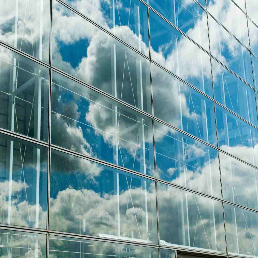images of clouds reflected in building, Oracle | DXC Technology