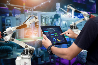 Worker controlling robotic assistant arm, Intelligent Operations | DXC Technology Customer story